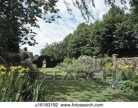 Mown grass path through large walled country garden View Large Photo Image Stock Image - Mown grass path through large walled country garden. Fotosearch