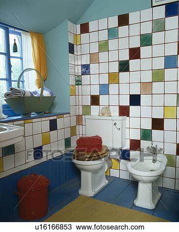 Multi-coloured wall tiles above bidet and toilet in country bathroom View Large Photo Image Stock Image - Multi-coloured wall tiles above bidet and toilet in country bathroom. Fotosearch