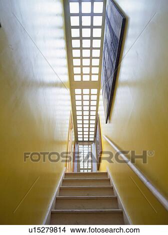 Picture - Narrow yellow staircase with tall glass brick wall. Fotosearch