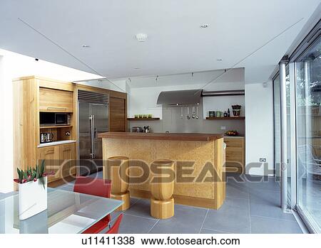 Oak units with tambour shutters in modern openplan kitchen dining room with stone compound floor tiles View Large Photo Image Stock Photo - Oak units with tambour shutters in modern openplan kitchen dining room with stone compound floor tiles. Fotosearch