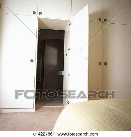 Open door on large fitted storage cupboard in bedroom View Large Photo Image Stock Image - Open door on large fitted storage cupboard in bedroom. Fotosearch