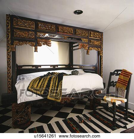 Stock Image - Ornately carved four-poster bed.. Fotosearch