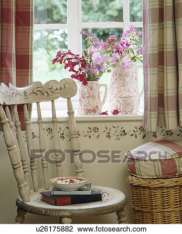 Stock Image - Painted white chair in front of window with stencilling below windowsill. Fotosearch