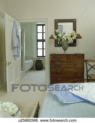 Pale blue cushions on bed in traditional townhouse bedroom with door open to en-suite bathroom View Large Photo Image Stock Photograph - Pale blue cushions on bed in traditional townhouse bedroom with door open to en-suite bathroom. Fotosearch