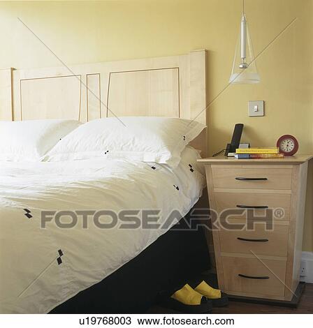 Pale wood bedside cabinet in small townhouse bedroom View Large Photo Image Stock Image - Pale wood bedside cabinet in small townhouse bedroom. Fotosearch