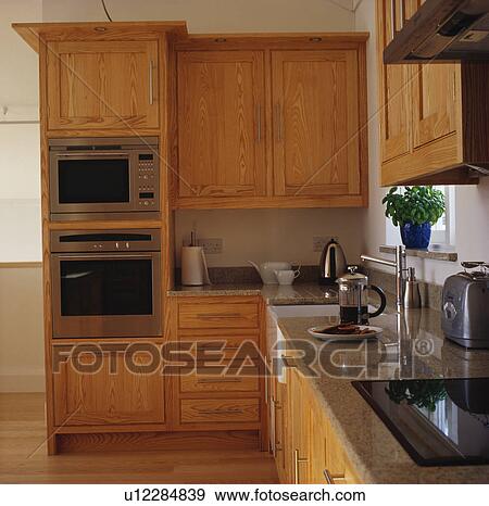 Pale wood fitted units and double oven in modern kitchen View Large Photo Image Stock Photo - Pale wood fitted units and double oven in modern kitchen. Fotosearch