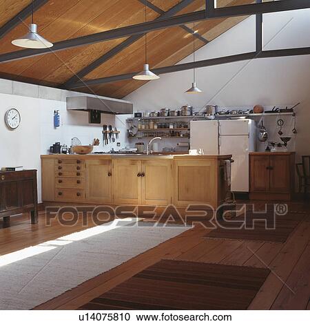 Pale wood fitted units in large modern kitchen with apex ceiling View Large Photo Image Stock Image - Pale wood fitted units in large modern kitchen with apex ceiling. Fotosearch