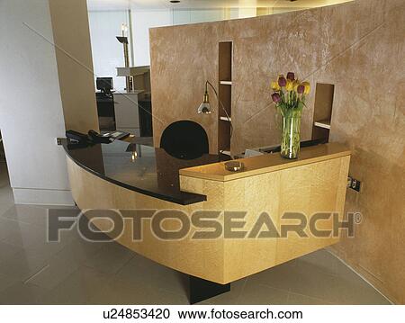 Pale wood reception desk with black worktop in modern office View Large Photo Image Stock Image - Pale wood reception desk with black worktop in modern office. Fotosearch