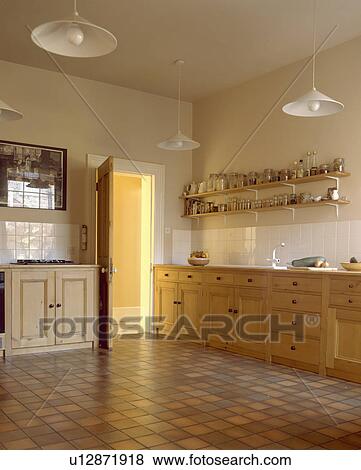 Stock Photo - Pale wooden units and vinyl floor tiles in townhouse kitchen. Fotosearch
