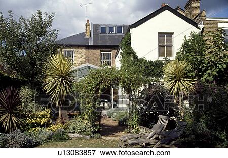 Stock Photo - Palm trees in garden of large coastal townhouse garden. Fotosearch