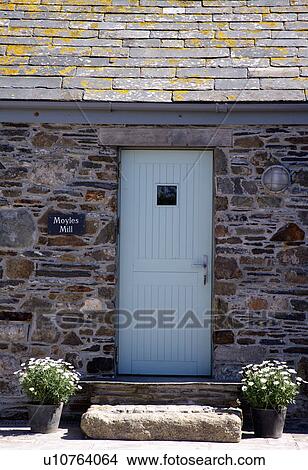 Picture - Pastel blue front door in stone coastal cottage. Fotosearch
