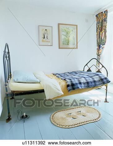 Pastel blue painted wooden floor and small cast-iron bed in simple white bedroom View Large Photo Image Stock Image - Pastel blue painted wooden floor and small cast-iron bed in simple white bedroom. Fotosearch