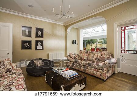 Stock Photo - Patterned sofas and faux animalskin coffee table in beige living room. Fotosearch