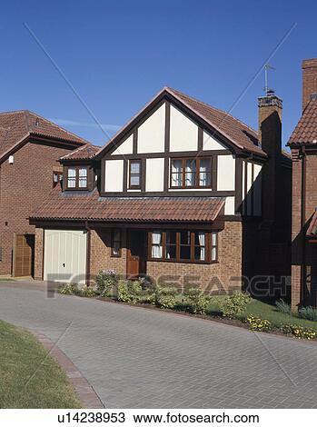 Stock Image - Paved drive in front of small detached newbuild house on estate. Fotosearch