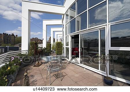 Stock Image - Paved roof terrace outside modern city penthouse apartment. Fotosearch