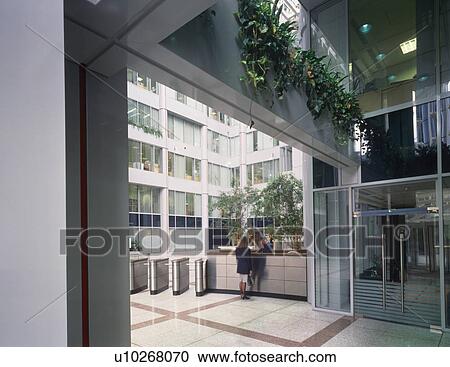 People at reception desk in modern city office block View Large Photo Image Stock Image - People at reception desk in modern city office block. Fotosearch