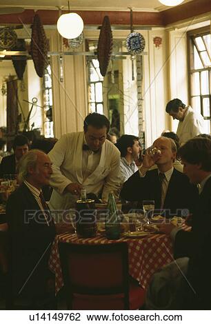 Stock Image - People dining at restaurant in London. Fotosearch