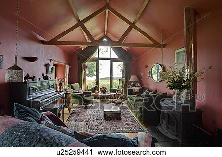 Stock Image - Piano in red living room extension with apex ceiling in . Fotosearch