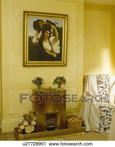 Picture above thirties fireplace in yellow living room with white lace-edged throw on armchair View Large Photo Image Stock Image - Picture above thirties fireplace in yellow living room with white lace-edged throw on armchair. Fotosearch