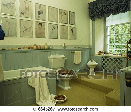 Stock Photo - Pictures above turquoise tongue+groove panelling in country bathroom. Fotosearch