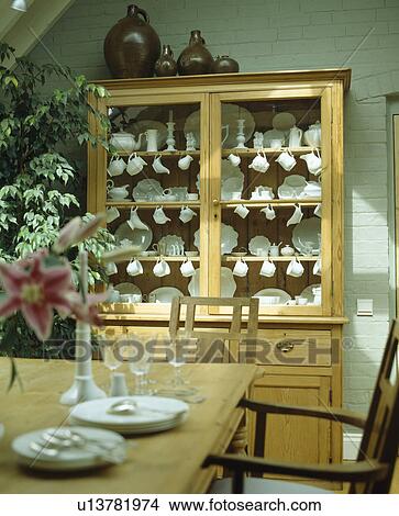 Pine dresser with glazed doors in pastel green country dining room View Large Photo Image Picture - Pine dresser with glazed doors in pastel green country dining room. Fotosearch