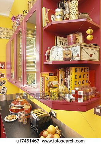 Stock Photo - Pink shelving in yellow kitchen. Fotosearch