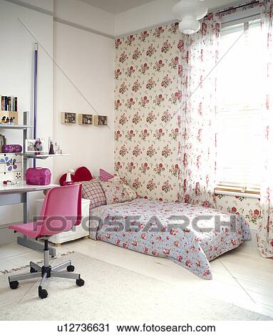 Pink swivel-chair at desk in teenage bedroom with rose-pattern wallpaper and bed with floral quilt View Large Photo Image Stock Image - Pink swivel-chair at desk in teenage bedroom with rose-pattern wallpaper and bed with floral quilt. Fotosearch