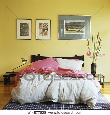 Pink throw and white duvet on bed in yellow bedroom View Large Photo Image Stock Photo - Pink throw and white duvet on bed in yellow bedroom. Fotosearch