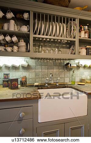 Plate rack above Belfast sink in olive green cottage kitchen View Large Photo Image Stock Photograph - Plate rack above Belfast sink in olive green cottage kitchen. Fotosearch