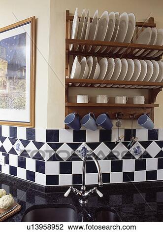 Plates on wooden rack above black+white wall tiles View Large Photo Image Stock Image - Plates on wooden rack above black+white wall tiles. Fotosearch