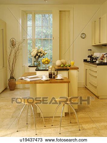 Plywood and chrome stools at breakfast bar in modern cream townhouse kitchen with wooden flooring View Large Photo Image Stock Image - Plywood and chrome stools at breakfast bar in modern cream townhouse kitchen with wooden flooring. Fotosearch