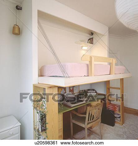 Stock Image - Pull-down bed above desk and chair in economy-style student's studio apartment. Fotosearch
