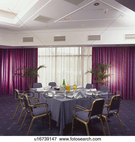 Stock Photo - Purple curtains and table with blue cloth in office boardroom. Fotosearch