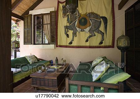 Rajasthan wall hanging on wall of veranda of Mallorcan house with comfortable sofas and wooden table View Large Photo Image Stock Image - Rajasthan wall hanging on wall of veranda of Mallorcan house with comfortable sofas and wooden table. Fotosearch