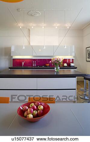 Red bowl of apples on table in modern kitchen with island unit with cast concrete resin worktop View Large Photo Image Stock Photo - Red bowl of apples on table in modern kitchen with island unit with cast concrete resin worktop. Fotosearch