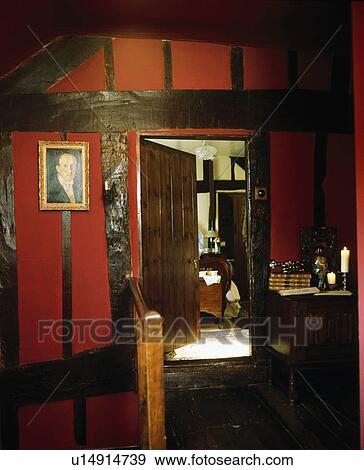 Stock Photo - Red landing with beamed walls and open door to bedroom. Fotosearch