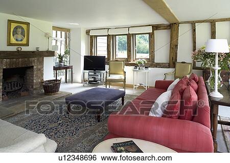 Red sofa in large white living room in country barn conversion View Large Photo Image Stock Photograph - Red sofa in large white living room in country barn conversion. Fotosearch