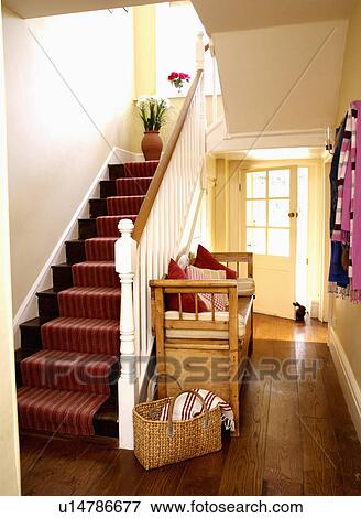 Stock Photo - Red striped carpet on stairs in country hall with straw basket beside pine settle. Fotosearch
