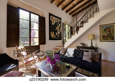 Rocking-chair in front of window with shutters in Mediterranean hall living room View Large Photo Image Stock Photo - Rocking-chair in front of window with shutters in Mediterranean hall living room. Fotosearch