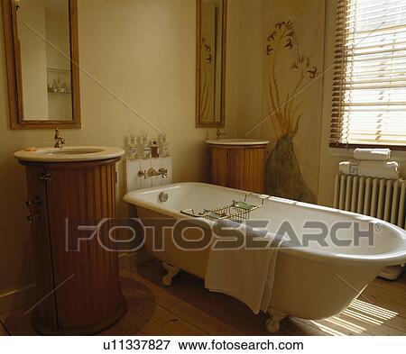 Rolltop bath in cream bathroom with double basins in panelled plinths View Large Photo Image Stock Photo - Rolltop bath in cream bathroom with double basins in panelled plinths. Fotosearch