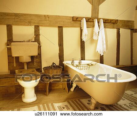 Stock Image - Rolltop bath in tradtional beamed country bathroom. Fotosearch