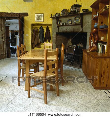 Rush-seated chairs at wooden table in country dining room with grey vinyl floor and large stone fireplace View Large Photo Image Picture - Rush-seated chairs at wooden table in country dining room with grey vinyl floor and large stone fireplace. Fotosearch