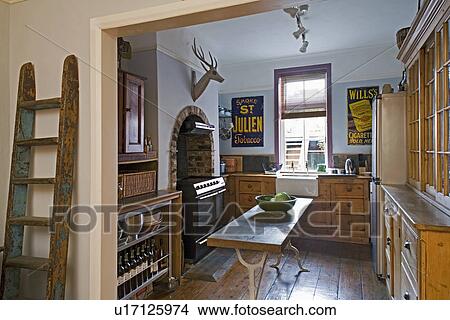 Rustic wooden ladder beside double doorway to pine kitchen with oak-topped table View Large Photo Image Picture - Rustic wooden ladder beside double doorway to pine kitchen with oak-topped table . Fotosearch