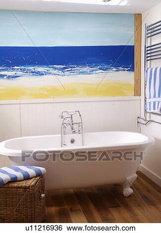 Seascape painted on wall above white rolltop bath in coastal bathroom View Large Photo Image Stock Photograph - Seascape painted on wall above white rolltop bath in coastal bathroom. Fotosearch