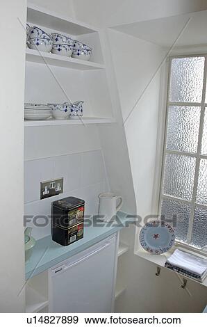 Shelves in alcove above fridge below pale blue shelf in small white apartment kitchen View Large Photo Image Stock Photo - Shelves in alcove above fridge below pale blue shelf in small white apartment kitchen. Fotosearch
