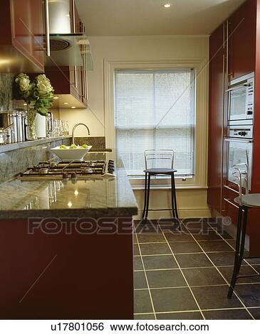 Slate flooring and red fitted units in modern townhouse kitchen View Large Photo Image Stock Photograph - Slate flooring and red fitted units in modern townhouse kitchen. Fotosearch