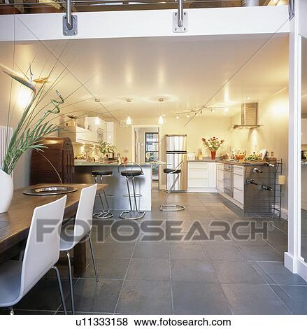 Slate flooring in modern open-plan dining room and kitchen in loft conversion View Large Photo Image Stock Photo - Slate flooring in modern open-plan dining room and kitchen in loft conversion. Fotosearch