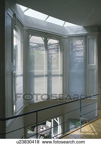 Slatted blinds on bay window of modern landing View Large Photo Image Stock Photo - Slatted blinds on bay window of modern landing. Fotosearch