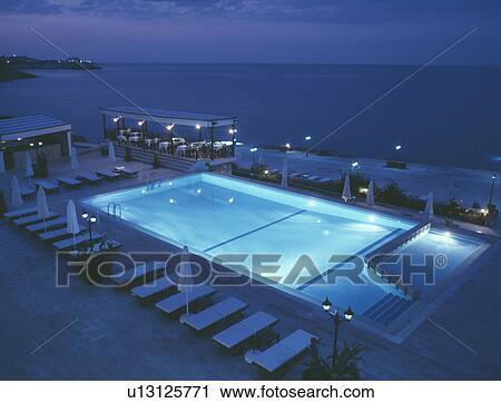 Small beachside cafe and loungers beside swimming pool underlit at night View Large Photo Image Stock Image - Small beachside cafe and loungers beside swimming pool underlit at night. Fotosearch