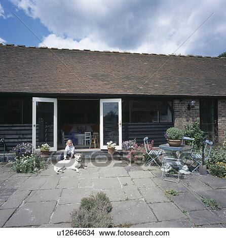 Small girl with golden labrador dog outside small barn conversion View Large Photo Image Picture - Small girl with golden labrador dog outside small barn conversion. Fotosearch